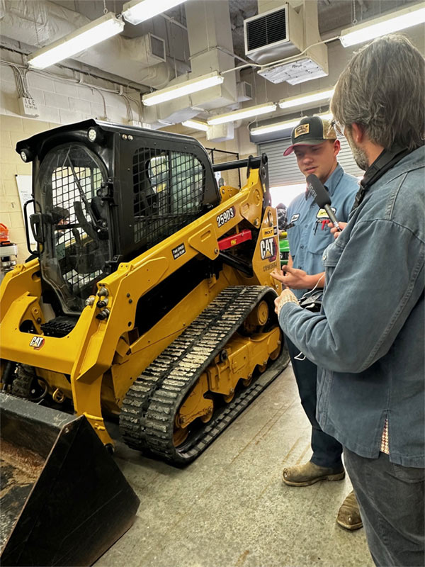 High school students working on a HOLT CAT skid steer loader as part of their ag mechanics training