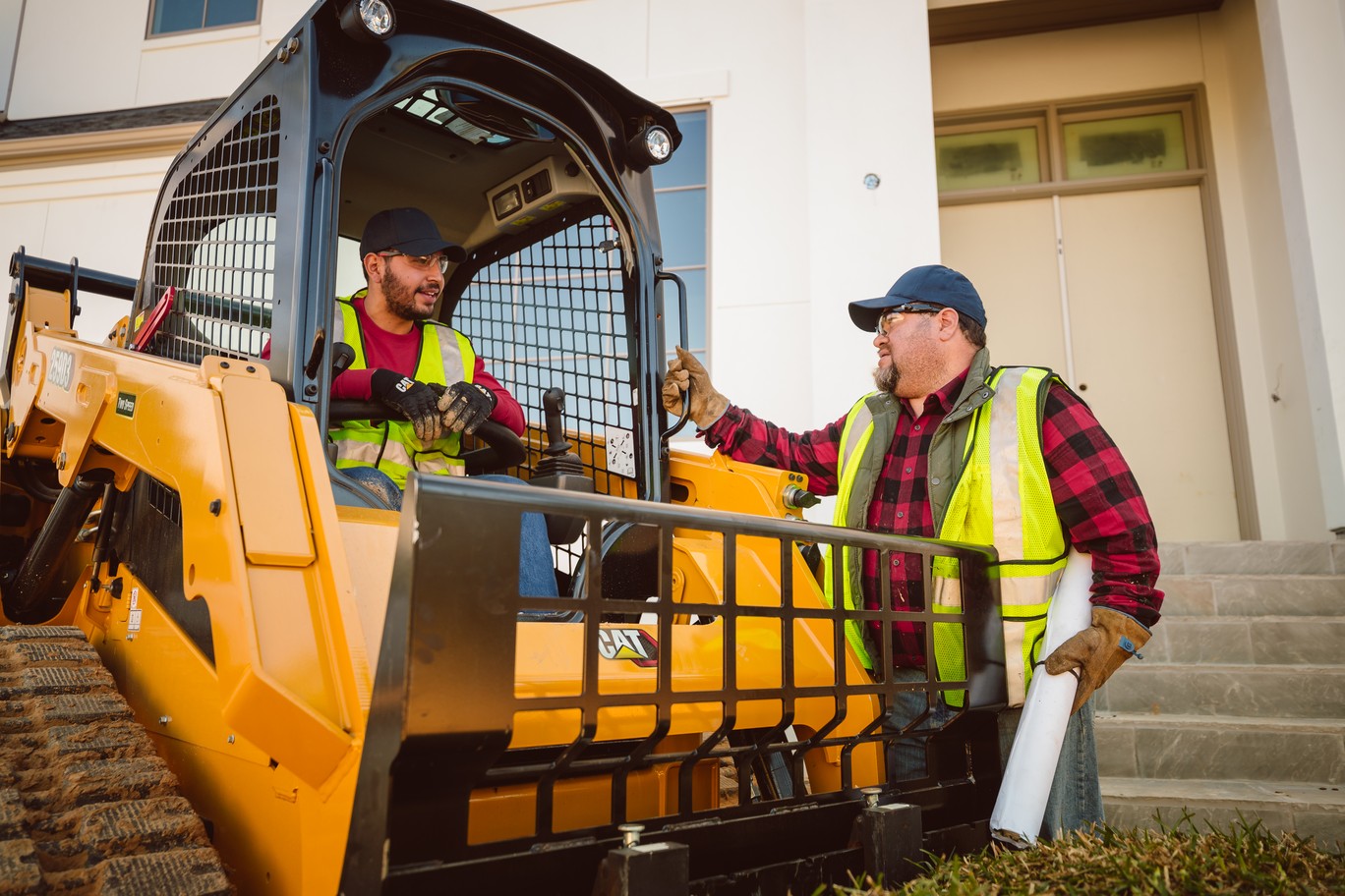 Demo specialist showing a customer a Cat compact track loader