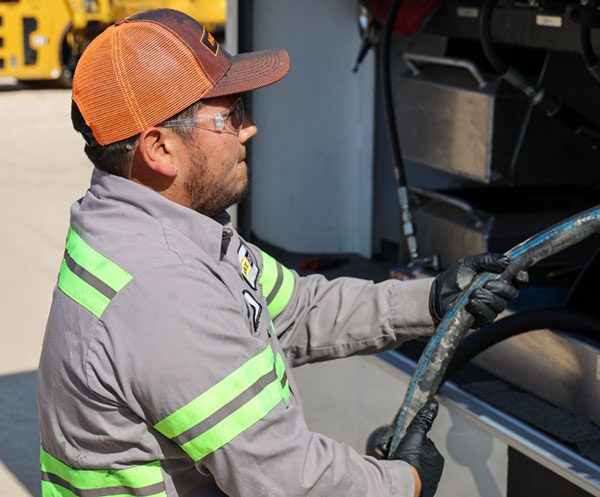 HOLT CAT IronPro service technician with hose at express service truck